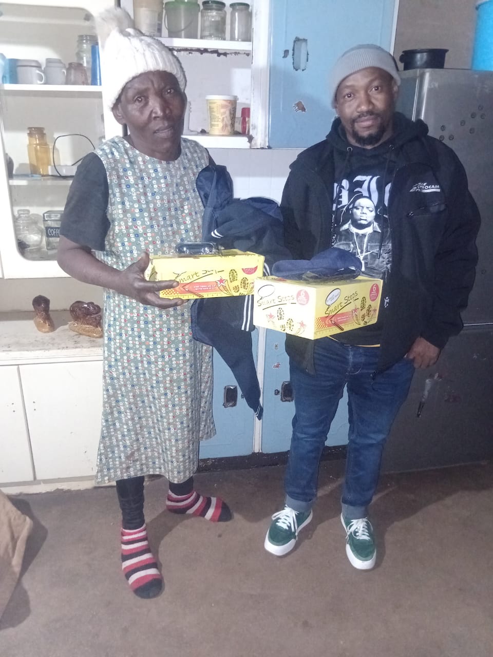 A grandmother receiving school uniform and Smart Steps shoes for her grandchild