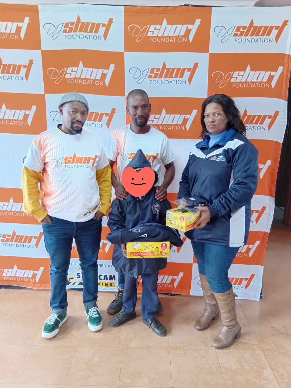 DJ Short Foundation team handing over uniform and shoes to a learner