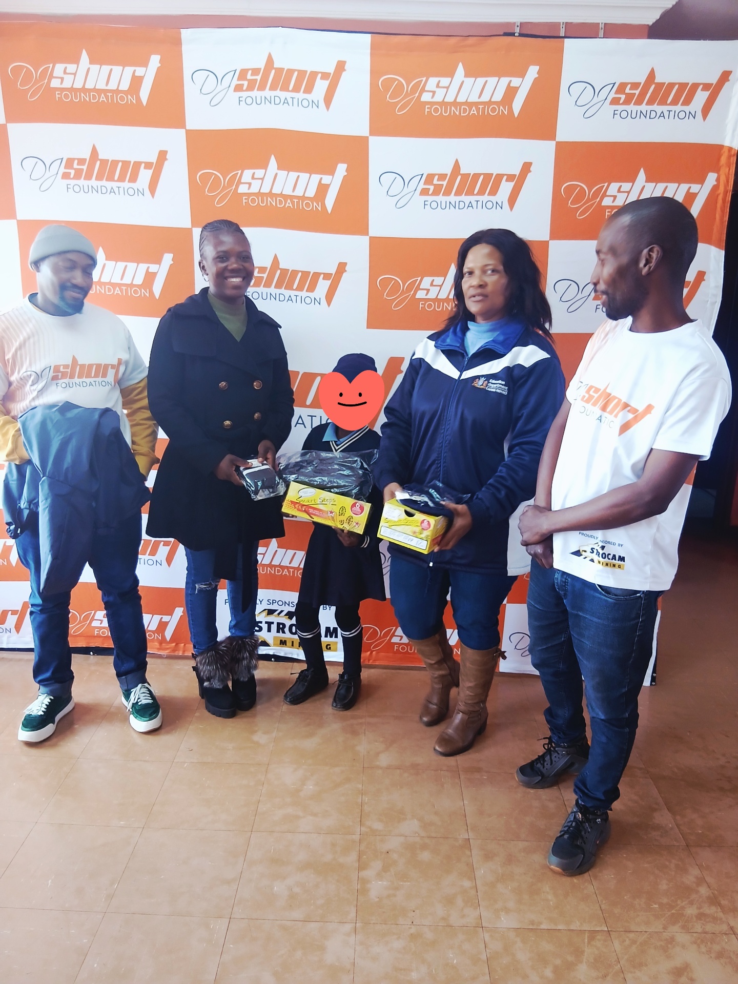 Learner receiving a free school uniform and shoes at Nyaya Boswa Primary School
